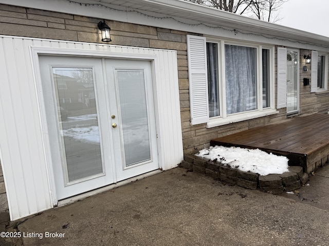 entrance to property featuring french doors and a wooden deck