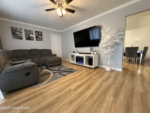 living room featuring ceiling fan, crown molding, a textured ceiling, and light hardwood / wood-style flooring