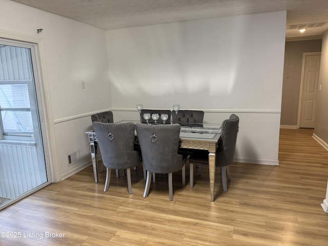 dining space with light hardwood / wood-style floors