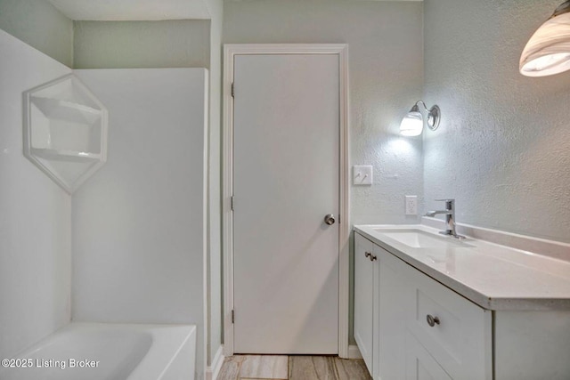 8923 La Costa Rd, Jeffersontown, KY 40299 - bathroom with vanity, a bath, wood finished floors, and a textured wall