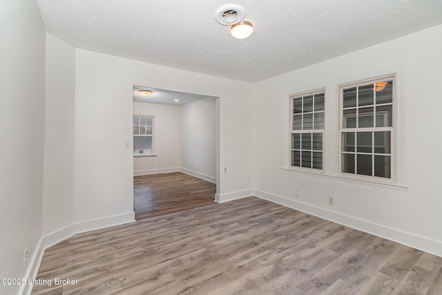 empty room with hardwood / wood-style floors and a textured ceiling