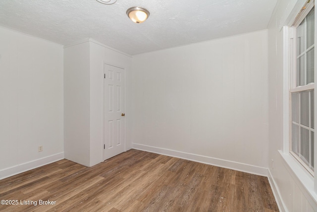 unfurnished room with hardwood / wood-style floors and a textured ceiling