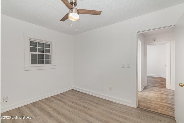 spare room with ceiling fan, light hardwood / wood-style flooring, and a textured ceiling