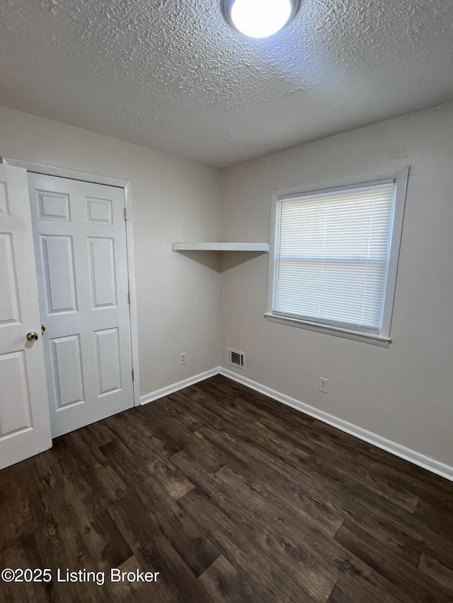 washroom with dark hardwood / wood-style floors and a textured ceiling