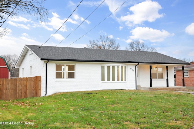 rear view of property with a porch and a yard