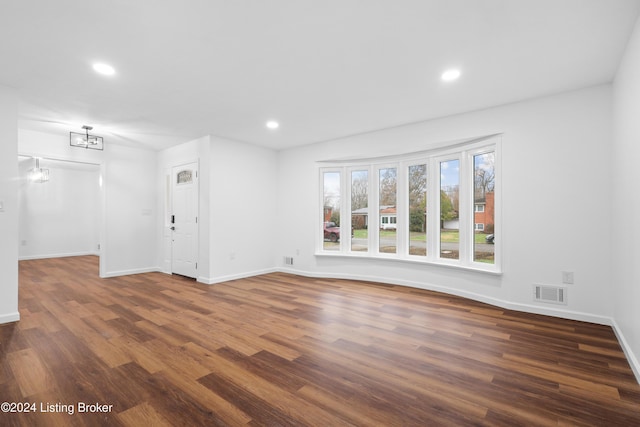 empty room with dark hardwood / wood-style flooring