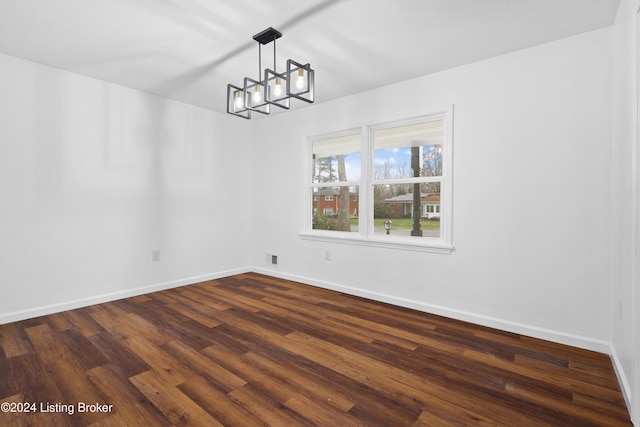 unfurnished dining area with dark hardwood / wood-style floors and a notable chandelier