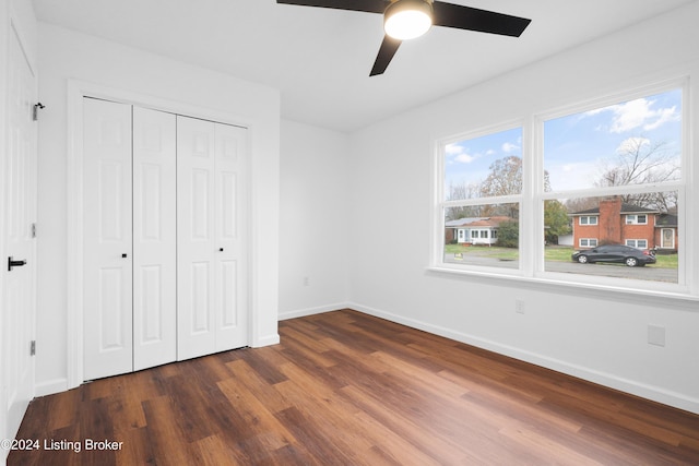 unfurnished bedroom featuring ceiling fan, a closet, and dark hardwood / wood-style flooring