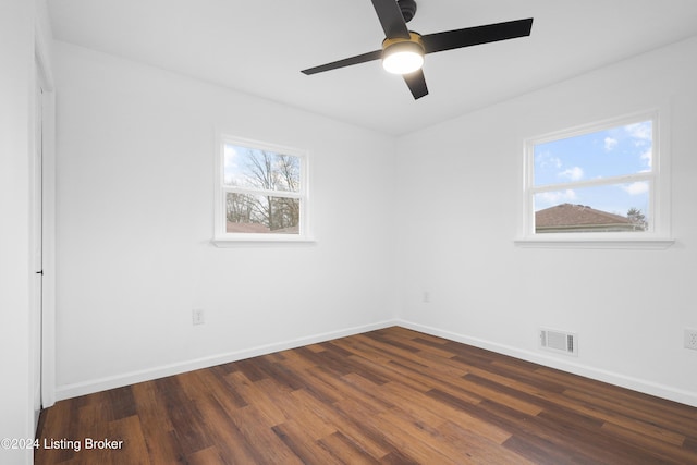 empty room with ceiling fan and dark hardwood / wood-style floors