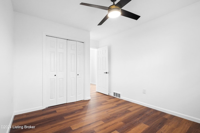 unfurnished bedroom with ceiling fan, a closet, and dark hardwood / wood-style flooring