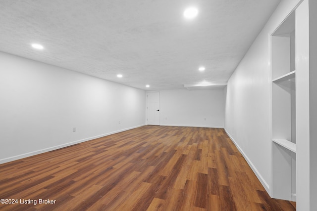 empty room featuring a textured ceiling and dark hardwood / wood-style floors