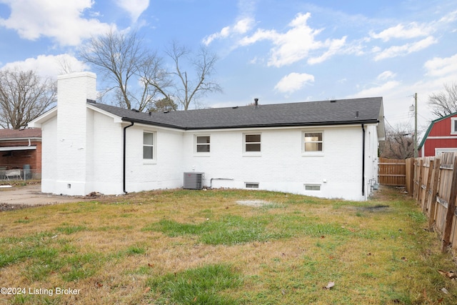 back of property featuring a lawn and central air condition unit