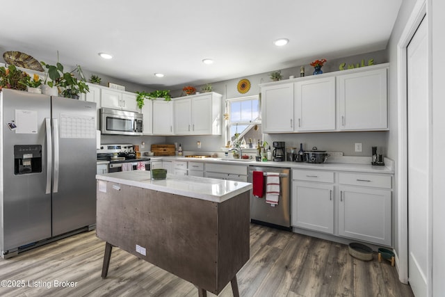 kitchen with white cabinets, a center island, dark hardwood / wood-style floors, and stainless steel appliances