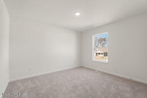 carpeted spare room with baseboards