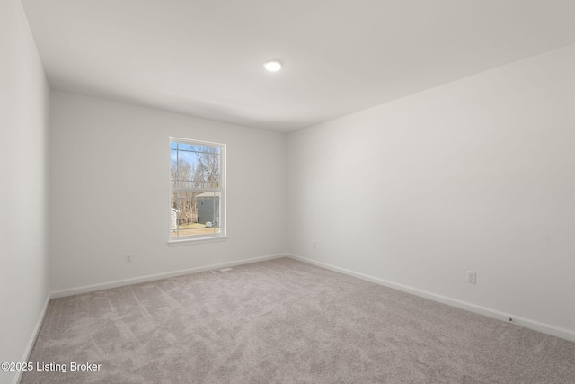 unfurnished room featuring carpet flooring, visible vents, and baseboards