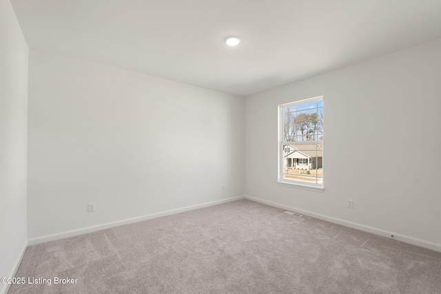 unfurnished room with carpet and baseboards