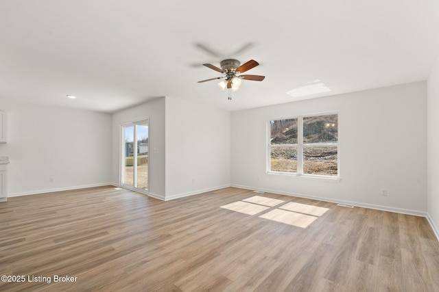 unfurnished room with baseboards, ceiling fan, and light wood-style floors