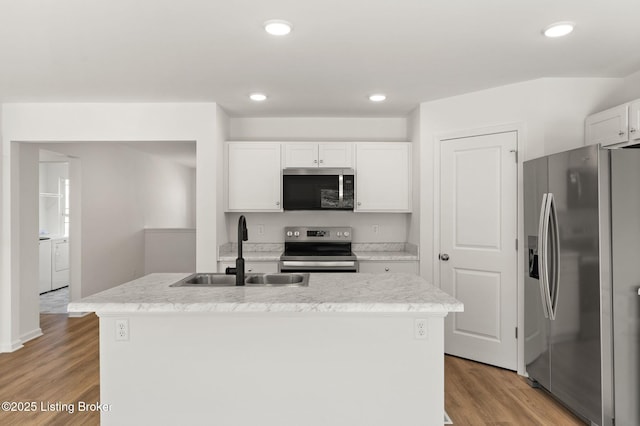 kitchen featuring recessed lighting, appliances with stainless steel finishes, white cabinets, a sink, and light wood-type flooring