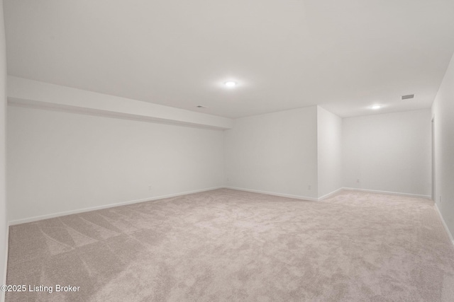 empty room with carpet floors, visible vents, and baseboards