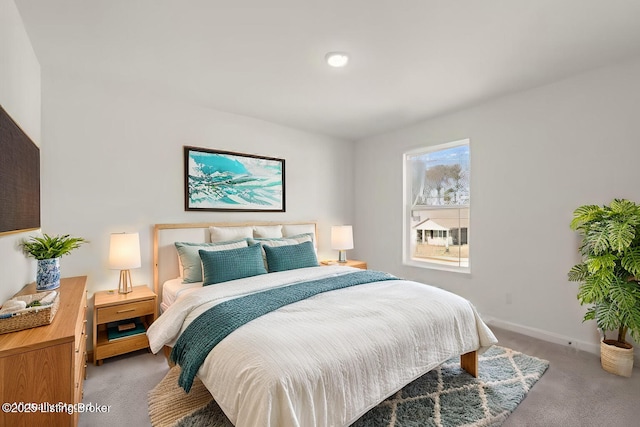 bedroom featuring light colored carpet and baseboards