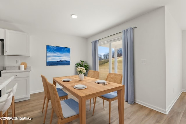 dining area featuring light wood-type flooring and baseboards