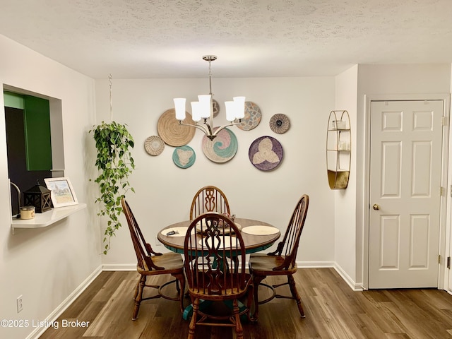 dining area featuring a textured ceiling, a notable chandelier, and dark hardwood / wood-style flooring