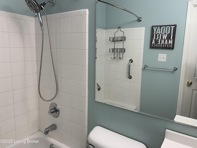 bathroom featuring toilet and tiled shower / bath combo