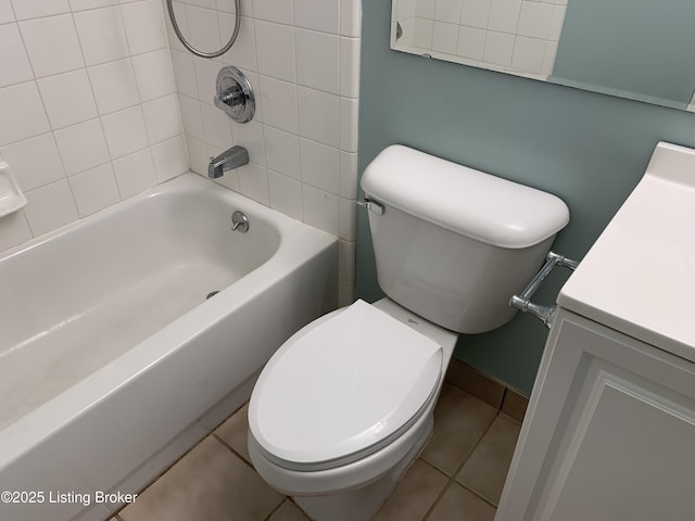 full bathroom with tiled shower / bath combo, toilet, tile patterned floors, and vanity