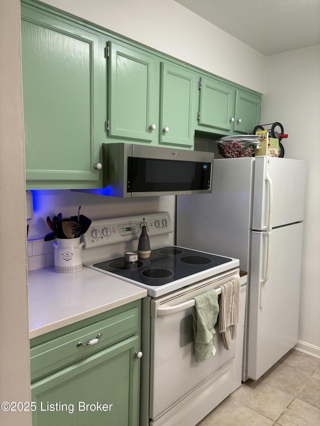 kitchen with white appliances, green cabinets, and light tile patterned floors