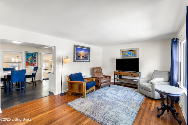 living room featuring a wealth of natural light and dark hardwood / wood-style flooring