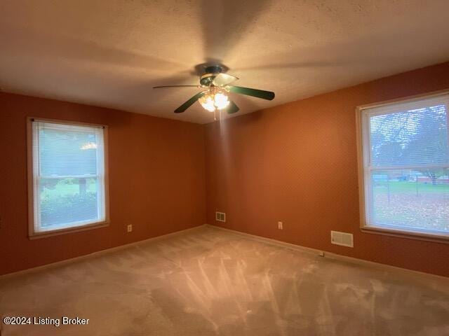 carpeted empty room featuring ceiling fan