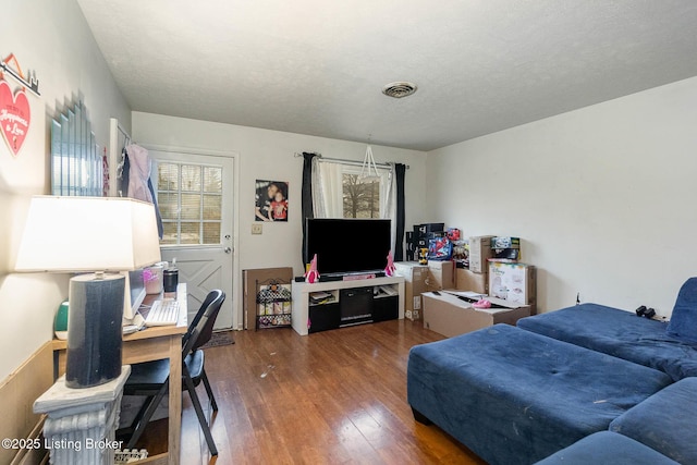 living room with a textured ceiling and dark hardwood / wood-style floors