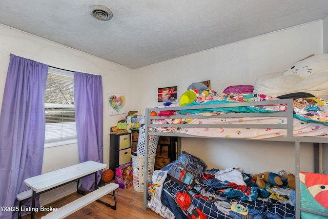 bedroom featuring hardwood / wood-style flooring and a textured ceiling