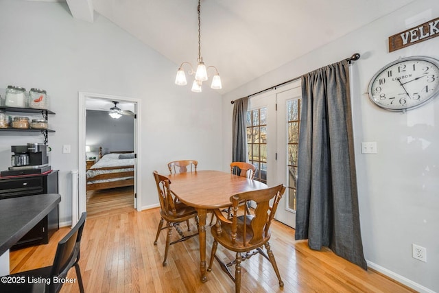 dining space with a chandelier, light hardwood / wood-style floors, and lofted ceiling