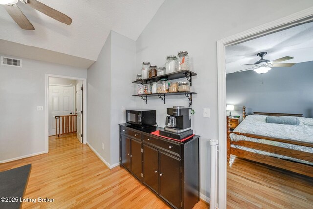 interior space with ceiling fan, lofted ceiling, and light wood-type flooring