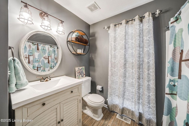 bathroom with hardwood / wood-style floors, toilet, and vanity