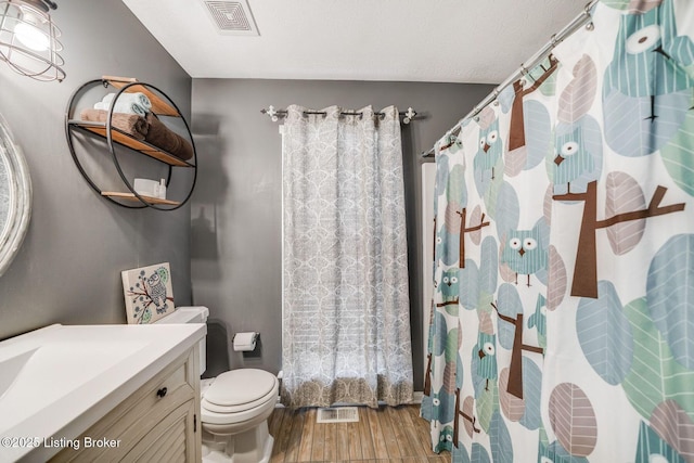 bathroom with vanity, toilet, and hardwood / wood-style floors