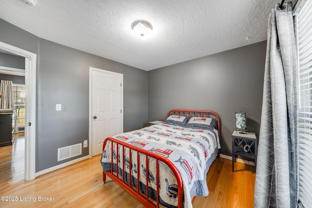 bedroom featuring hardwood / wood-style flooring and a textured ceiling