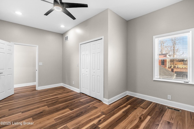 unfurnished bedroom with ceiling fan, a closet, and dark hardwood / wood-style floors