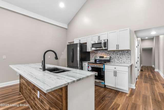 kitchen featuring light stone countertops, white cabinetry, stainless steel appliances, sink, and a kitchen island with sink