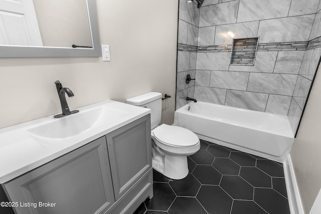 full bathroom featuring tiled shower / bath combo, vanity, toilet, and tile patterned flooring