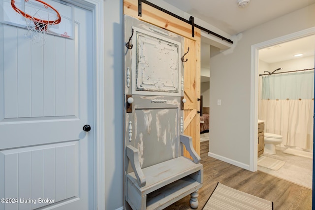 interior space with a barn door and hardwood / wood-style flooring