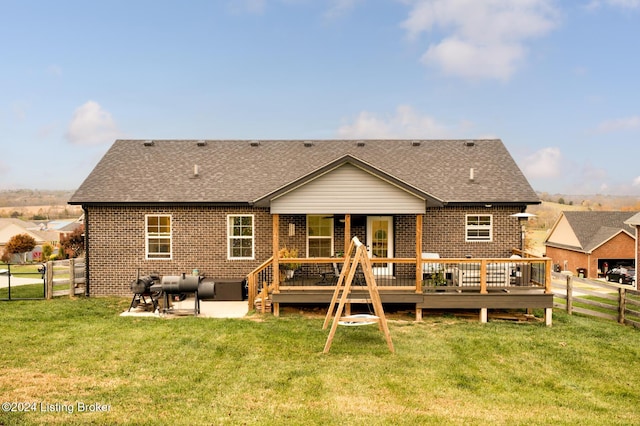 back of house featuring a patio area, a wooden deck, and a lawn