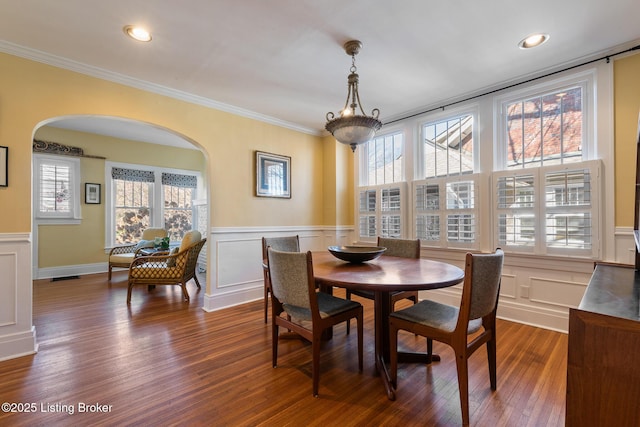 dining area with ornamental molding and dark hardwood / wood-style floors