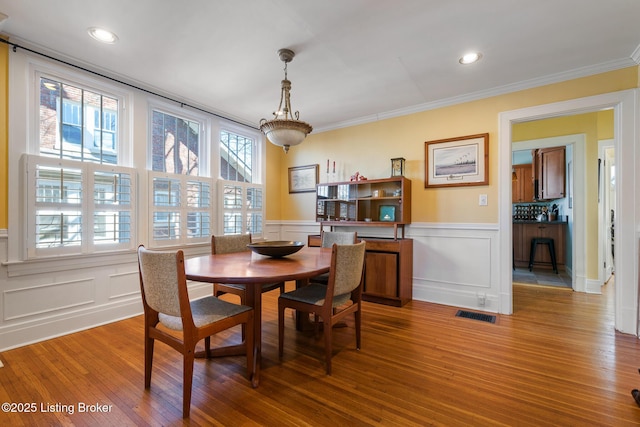 dining space featuring ornamental molding and hardwood / wood-style floors