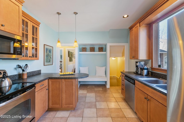 kitchen with sink, hanging light fixtures, light tile patterned floors, kitchen peninsula, and stainless steel appliances