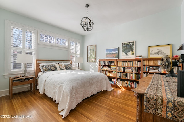 bedroom with an inviting chandelier and light wood-type flooring