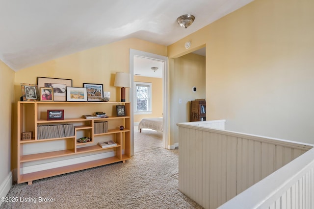 hall featuring vaulted ceiling and carpet