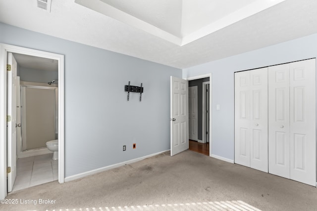 unfurnished bedroom featuring light carpet, a closet, and connected bathroom