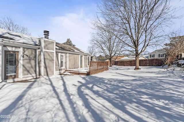 yard covered in snow with a deck